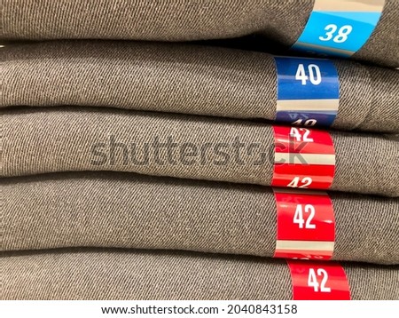 Photo of a pile of jeans of various sizes being sold at the mall