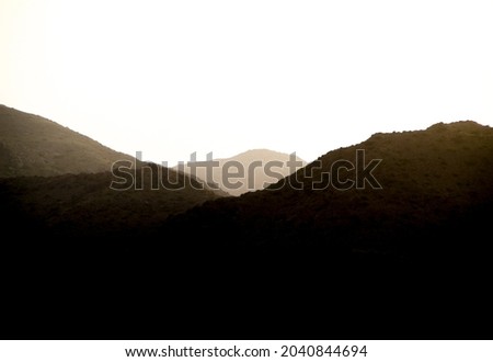 Clear morning sky with silhouettes of mountains in Spain. Monochrome picture.