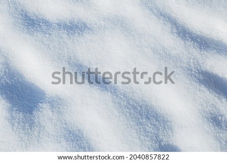 Natural snow - winter or Christmas background. White wavy surface captured outdoor from above (top view).