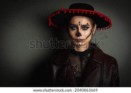 close up portrait of Calavera Katrina. Sugar skull makeup in a hat on a gray background. Dia-de -los -muertos. Day of the Dead. Halloween
