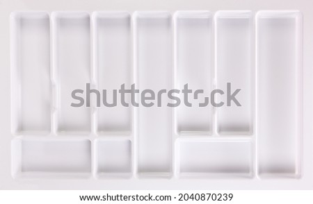Empty white plastic container for cutlery.