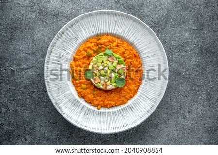 Shrimp and avocado tartare with risotto in seafood broth. Ready menu for the restaurant. Neutral gray blue textured background