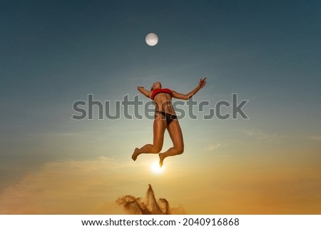 Volleyball player. Jump of young girl, playing volleyball on the beach.