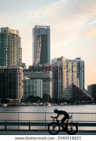 A vertical shot of a cyclist on the street with skyscrapers in the background
