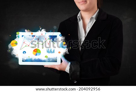 Person holding a white touchpad with cloud technology and charts