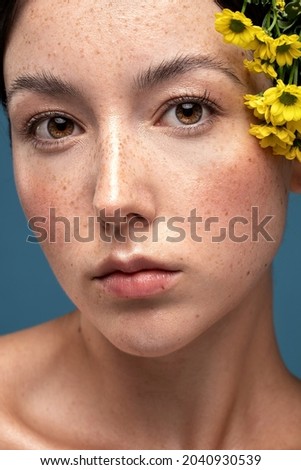 Beauty portrait of young swedish natural woman with freckles on face. Girl is looking at the camera. Closeup photo. Skin care concept. 
