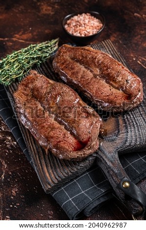 BBQ roasted Shoulder Top Blade cut or Australia wagyu oyster blade beef steak. Dark background. Top View Royalty-Free Stock Photo #2040962987