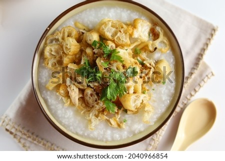 Bubur Ayam or Indonesian Rice Porridge with Shredded Chicken, cheese stick and cakwe. Top view Royalty-Free Stock Photo #2040966854