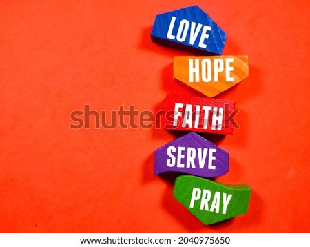 Business concept.Text LOVE HOPE FAITH SERVE PRAY writing on colored block on a red background.