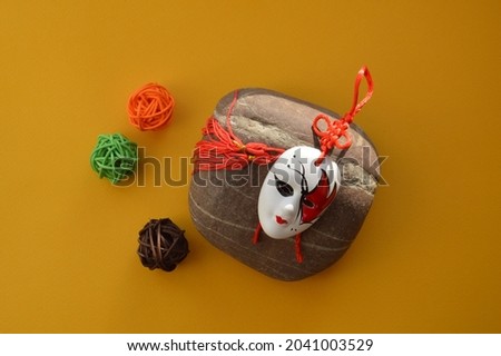 Mysterious carnival mask with objects on a the yellow background