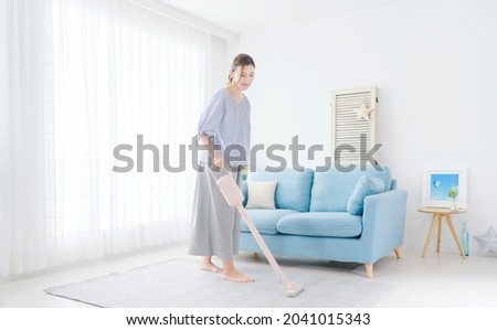 Asian woman cleaning at the living room