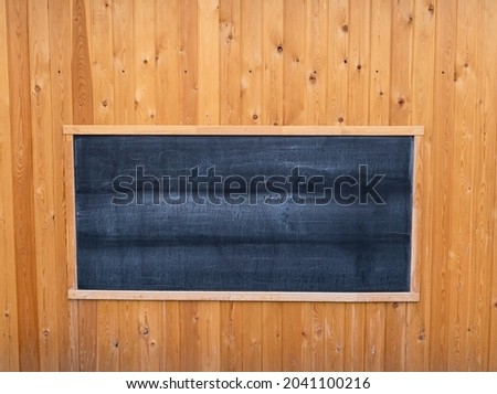 A rectangular chalk board on a wooden background. The texture of wooden boards, wooden boards, free space on a chalk board.