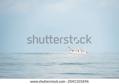 Fishing boat with nets cast into the sea