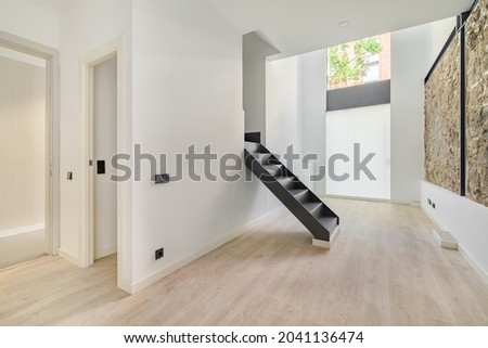 Mix of new and old architecture. Refurbished apartment with restored ancient wall left from old city buildings. Interior of empty renovated room in a duplex flat. Royalty-Free Stock Photo #2041136474