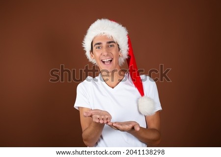 Christmas and New Year. A funny young guy enjoys the holidays. Brown background.