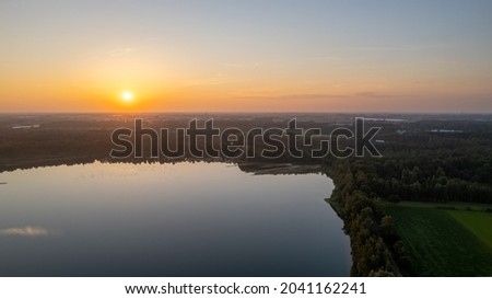 Beautiful, colorful sky over a lake at sunset. Peaceful scene, no one in sight. . High quality photo