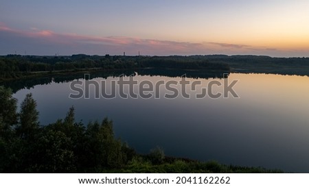 Beautiful, colorful sky over a lake at sunset. Peaceful scene, no one in sight. . High quality photo