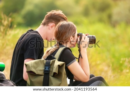 Couple of young tourists taking photo in countryside
