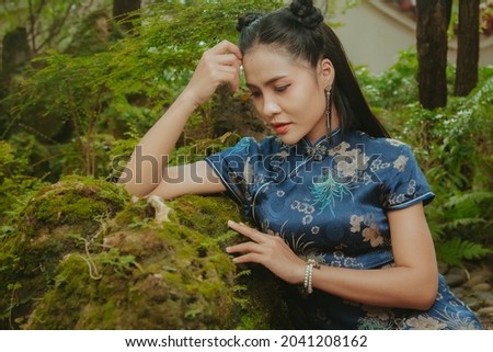 Beautiful Asian Asian woman wearing traditional Cheongsam dress, Blue dress In the chinese new year