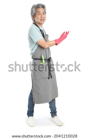 The senior Asian housekeeper standing on the white background.