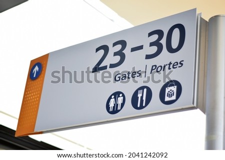 Generic wayfinding sign for airport gates, toilets, food court, and shopping center.