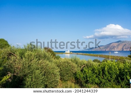 Salina island (Aeolian archipelago), Messina, Sicily, Italy, 08.17.2021: view of the salt lake with the white lighthouse in the background in "Punta Lingua".