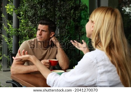 Man having boring date with talkative woman in outdoor cafe Royalty-Free Stock Photo #2041270070