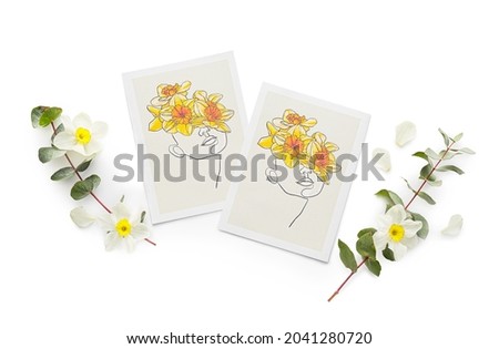 Greeting cards and narcissus flowers on light background
