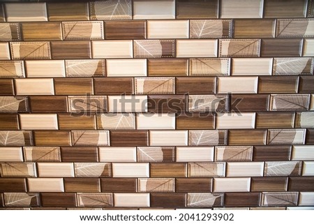 The background is made of rectangular ceramic tiles with a light brown pattern. Backgrounds design textures.