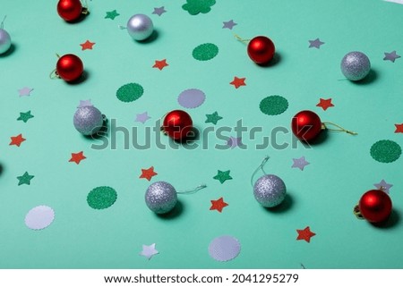 Composition of christmas decorations with baubles and stars on green background. christmas, tradition and celebration concept.