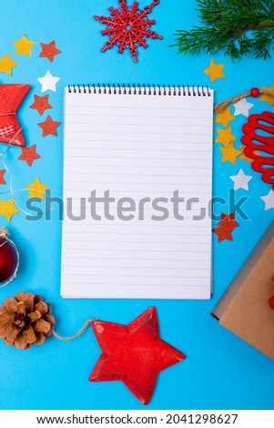 Composition of notebook with copy space and christmas decorations on blue background. christmas, tradition and celebration concept.