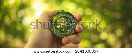 Orienteering in the woods with compass in the hand, banner 