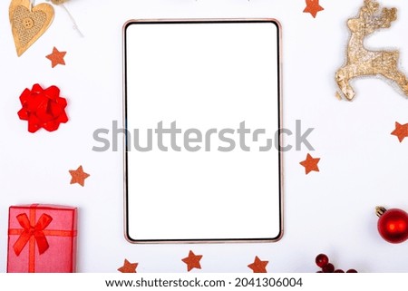 Composition of tablet with copy space and christmas decorations on white background. christmas, tradition and celebration concept.