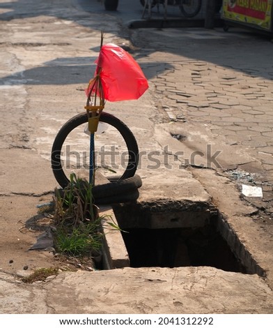 Red plastic attached to a bamboo to warn of potholes