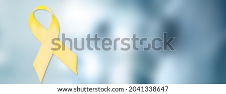 Yellow Ribbon on colored background for supporting people living and illness.