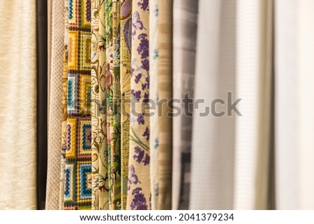 Blurred samples of various colorful curtains in the store are sold at retail.