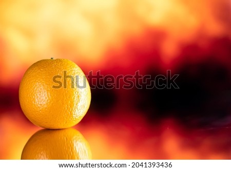 Orange fruit in front of a mirror. Orange background with orange fruit