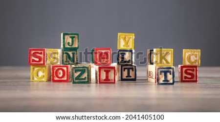 Colorful wooden cubes with letters on the wooden table.