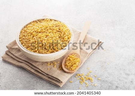 bulgur grits in a bowl on a napkin, gray background, space for text, horizontally
 Royalty-Free Stock Photo #2041405340