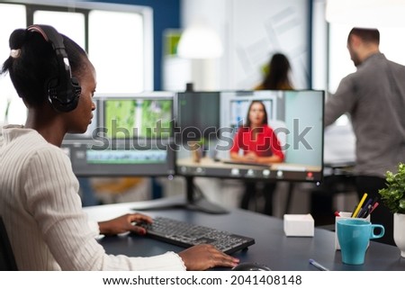 Video editor in web online conference with project creator on video call editing business client work, getting feedback on movie using post production software on two monitors in start up office