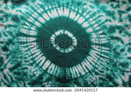 Tie dye green background with half circle layers of dye pattern fading from green to white dye fabric textile