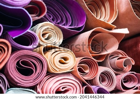 Rolls of natural leather in a storage . Pink colours  Royalty-Free Stock Photo #2041446344