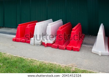 red and white plastic protective barriers or fences on a construction site or on the road