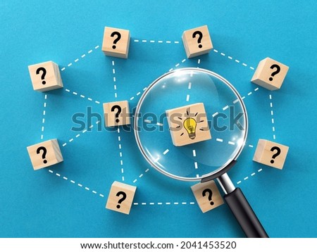 Creative idea or problem solving concept, magnifying glass and light bulb icons on wooden blocks with blue background
