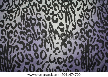 Illustration of leopard print on fibrous black fabric with a soft light blue background on winter bed padding.