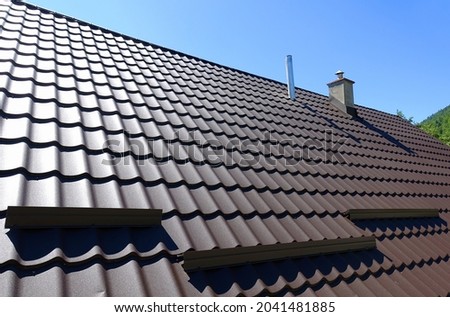   Brown corrugated metal profile roof installed on a modern house. The roof of corrugated sheet. Roofing of metal profile wavy shape. Modern roof made of metal. Metal roofing.                          Royalty-Free Stock Photo #2041481885