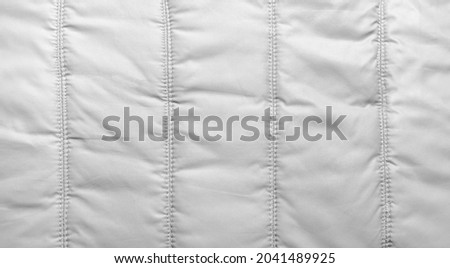 Bologna fabric seamed texture surface, white colored material. Royalty-Free Stock Photo #2041489925