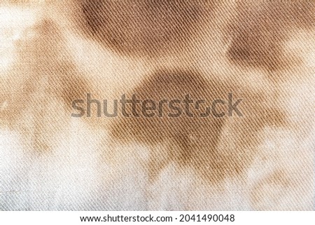 Texture backdrop photo of brown stained and burned old white colored cloth.