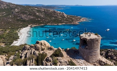 Aerial view of the ruins of the Genoese tower of Roccapina in the South of Corsica, France - Rounded tower overlooking the bay and beach of Roccapina with turquoise waters in the Mediterranean Sea Royalty-Free Stock Photo #2041497413