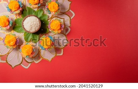 Happy Dussehra. Yellow flowers, green leaf and rice on red background. Dussehra Indian Festival concept. Royalty-Free Stock Photo #2041520129